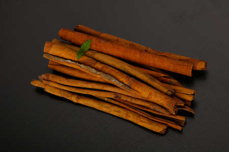 Cinnamon sticks on the black wood background
