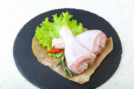 Raw chicken leg with herbs and spices ready for cookingの写真素材