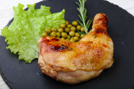 Roasted chicken leg with green peas and rosemaryの写真素材