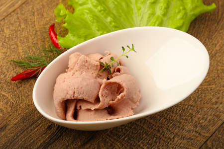 Liver pie in the bowl with salad leaves and thyme