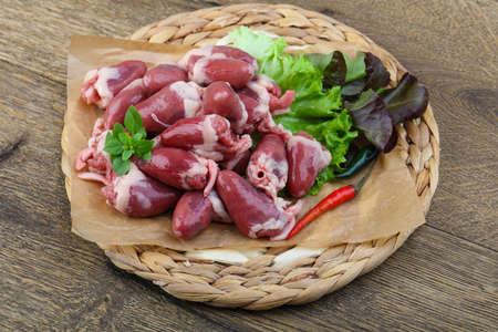 Raw chicken hearts on the plate ready for cookingの写真素材