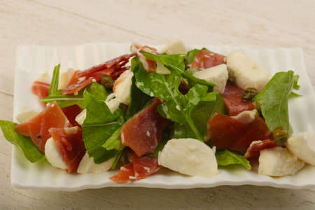 Salad with proscuitto, mozzarella, rucola and olive oilの写真素材