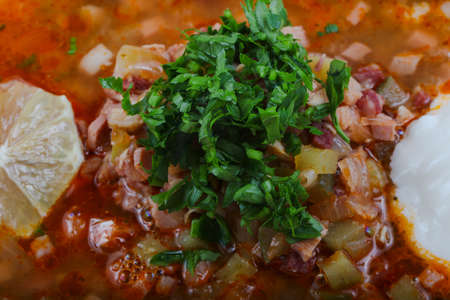 Solyanka mix soup with sausages, olives and lemon