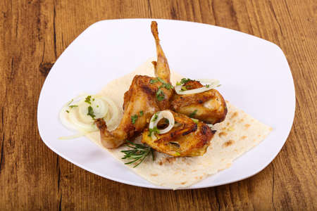 Grilled quail with onion and parsley on wood backgroundの写真素材