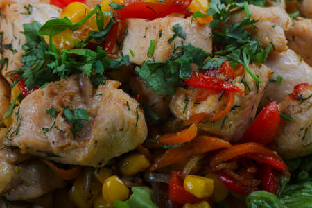 Roasted chicken with corn, pepper and tomatoの写真素材