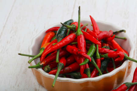 Hot chili pepper heap on the wood backgroundの写真素材