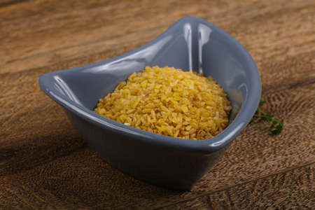 Raw bulgur heap in the bowl ready for cookingの写真素材