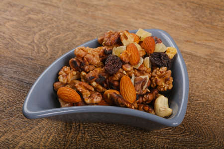 Nut mix heap in the bowl over wood backgroundの写真素材