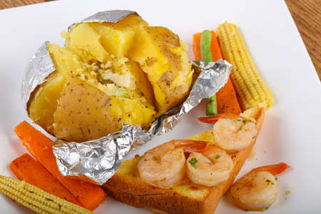 Baked potato with shrimps, herbs and garlicの写真素材
