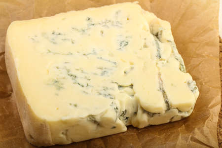 Gorgonzola cheese slice with salad leaves over the wooden background