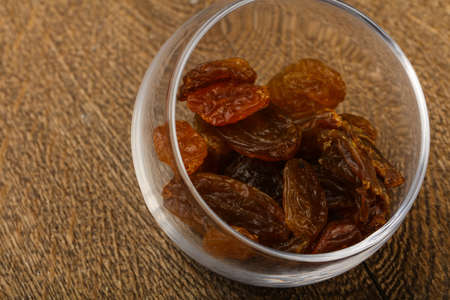 Dry Raisin in the bowl over the wooden backgroundの写真素材