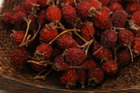 Dry hawthorn heap in the bowl over wooden backgroundの写真素材