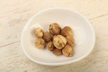 Cardamom heap in the bowl over wooden background