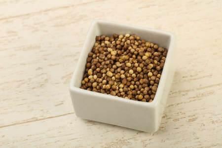 Coriander seeds heap over the wooden backgroundの写真素材