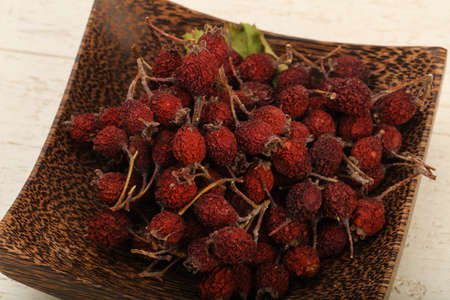 Dry hawthorn heap in the bowl over wooden backgroundの写真素材