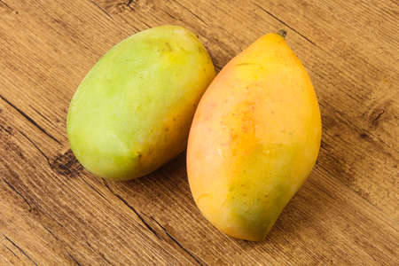 Sweet mango fruit over the wooden backgroundの写真素材