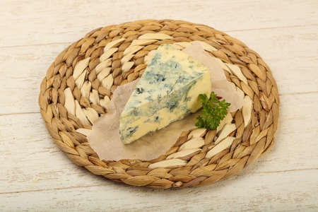 Blue cheese with parsley over wooden backgroundの写真素材