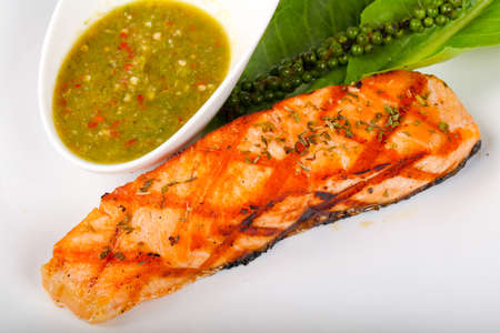 Grilled salmon with lime, pepper and sauceの写真素材