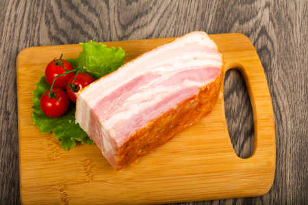 Raw bacon over wooden backgroundの写真素材
