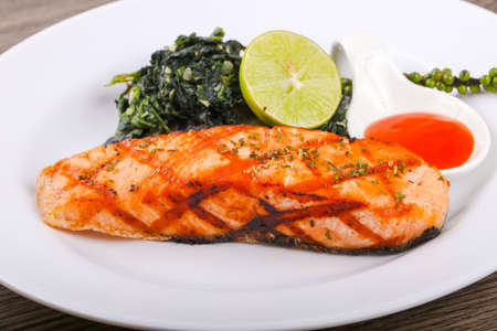 Grilled salmon with lime, pepper and sauceの写真素材