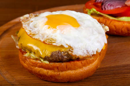 Burger with egg, ham and onionの写真素材