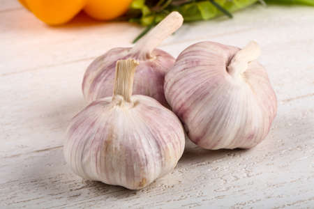Garlic heap over the wooden backgroundの写真素材