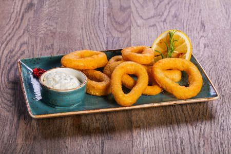 Squid rings with sauce served lemonの写真素材