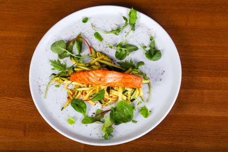 Grilled salmon with vegetables and saladの写真素材