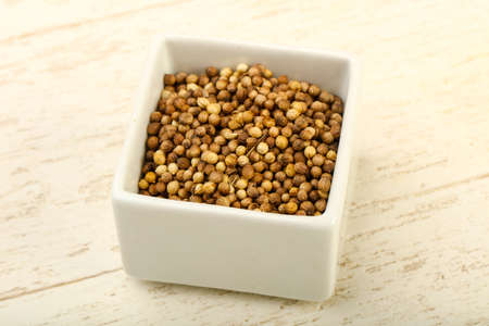 Coriander seeds heap over the wooden backgroundの写真素材