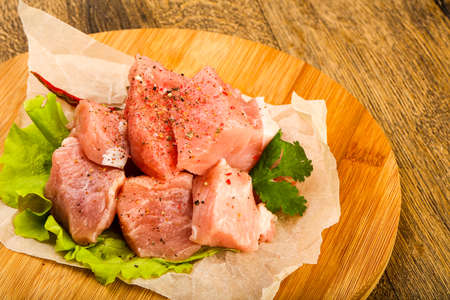Raw pork pieces with pepper and salt - ready for cookingの写真素材