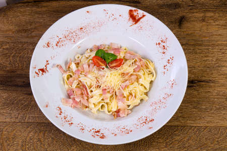 Carbonara pasta with cheese and tomatoの写真素材