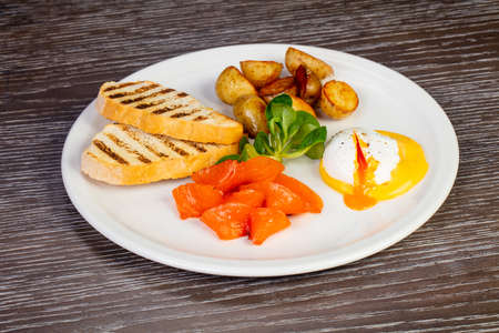 Tasty egg poached with salmon and potatoes