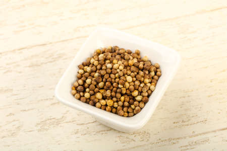 Coriander seeds heap over the wooden backgroundの写真素材