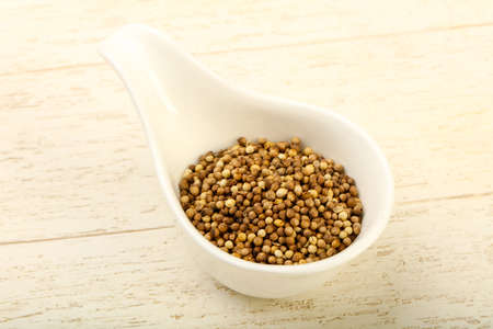Coriander seeds heap over the wooden backgroundの写真素材