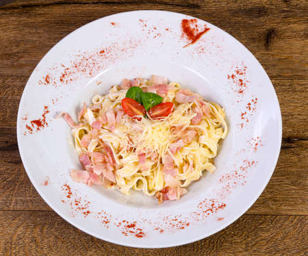 Carbonara pasta with cheese and tomatoの写真素材