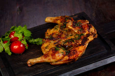 Grilled chicken with spices over wooden