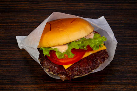 Tasty hot burger over wooden backgroundの写真素材