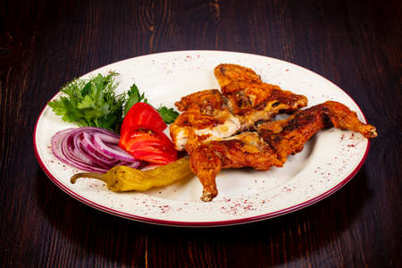 Roasted chicken wtih vegetables over wooden backgroundの写真素材