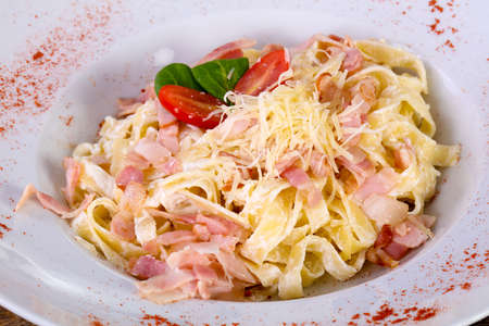 Carbonara pasta with cheese and tomatoの写真素材