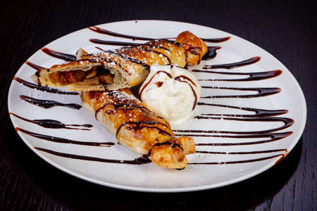 Delicious pie with raisins, with ice cream, chocolate syrupの写真素材
