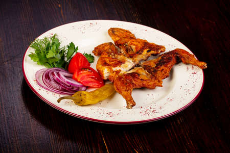 Roasted chicken wtih vegetables over wooden backgroundの写真素材