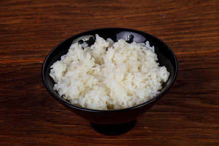 Steamed rice in the plate over wooden backgroundの写真素材