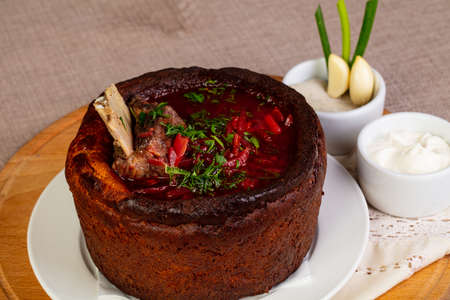 Traditional Borsch with meat and cabbage in Bread