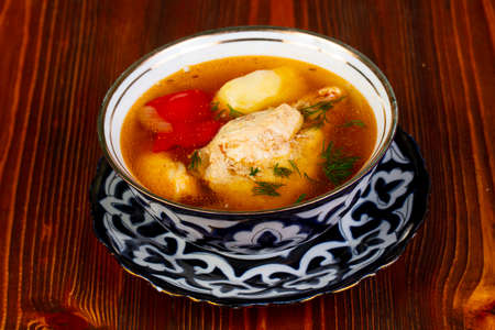 Chicken soup with vegetables over woodenの写真素材