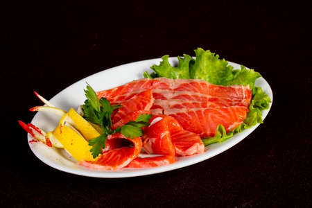 Sliced salmon sashimi with parsley and lemon