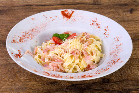 Carbonara pasta with cheese and tomatoの写真素材