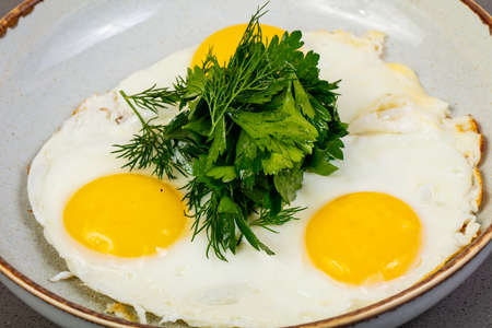 Three Fried eggs with herbsの写真素材