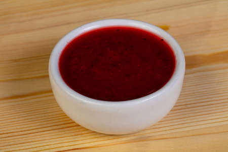Strawberry jam in the bowl over the wooden backgroundの写真素材