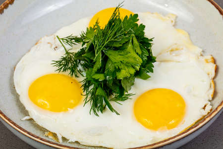 Three Fried eggs with herbsの写真素材