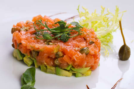 Tartar with salmon and avocado served capers and balsamicoの写真素材